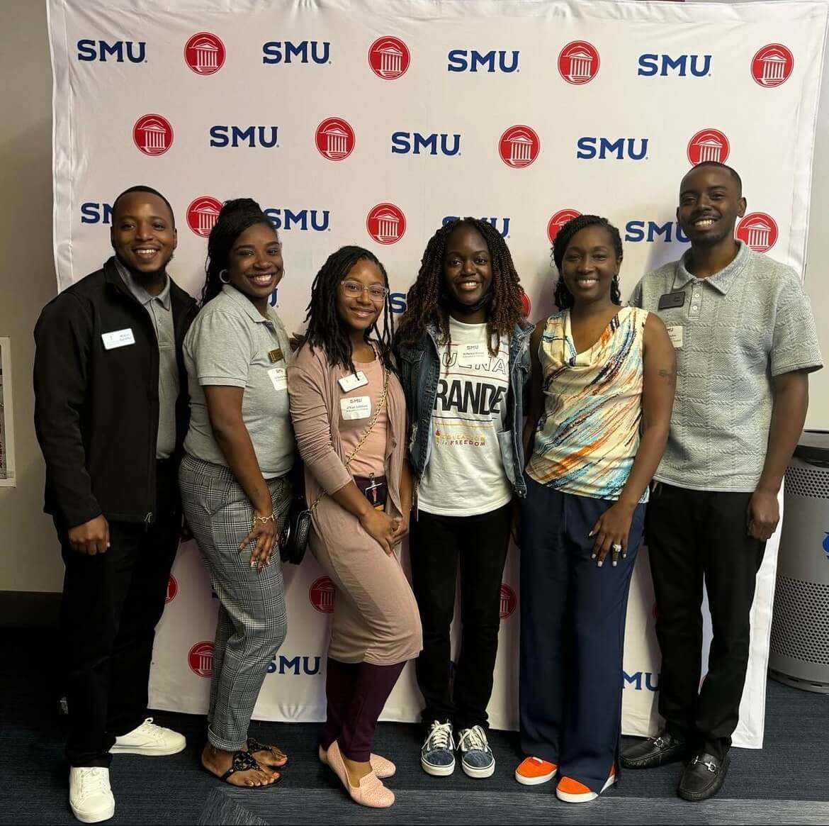 Students pose in front of an SMU backdrop