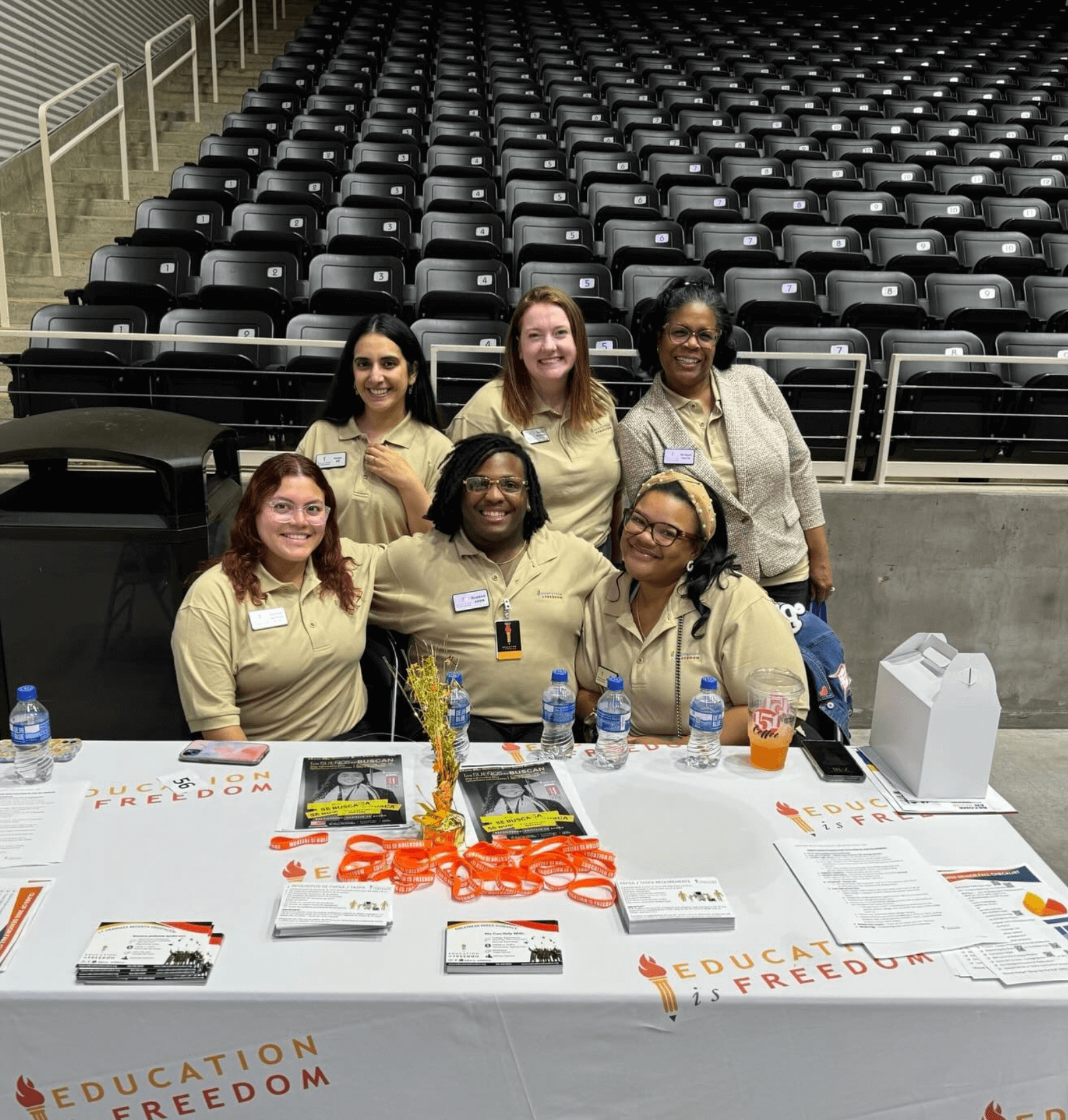 A group of students pose behind a table